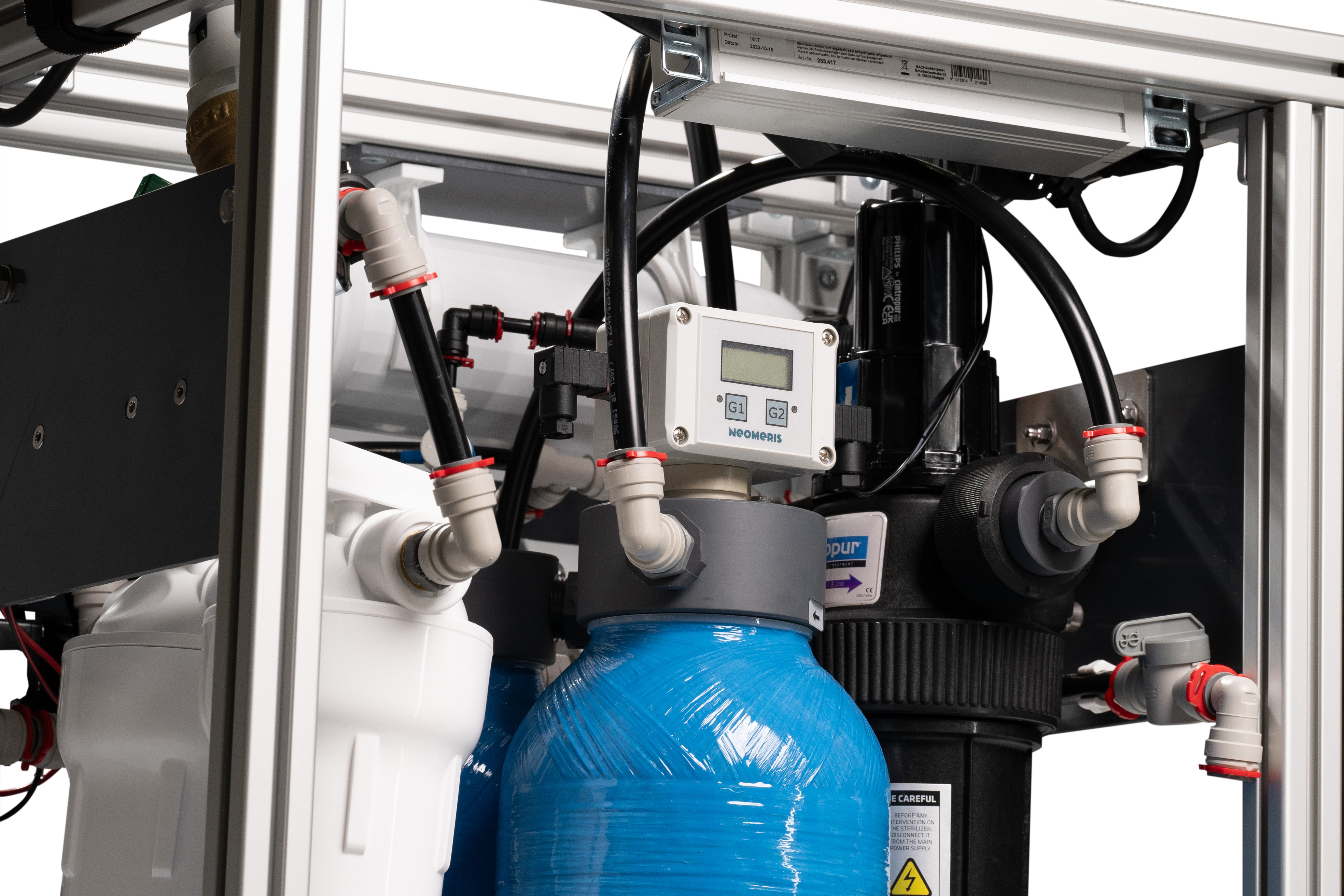 NeoPureMini schräg von oben, Steuerdisplay und Dosierflasche, mehrstufiges Filtersystem, platzsparend montiert, Untertisch-Wasseraufbereitung